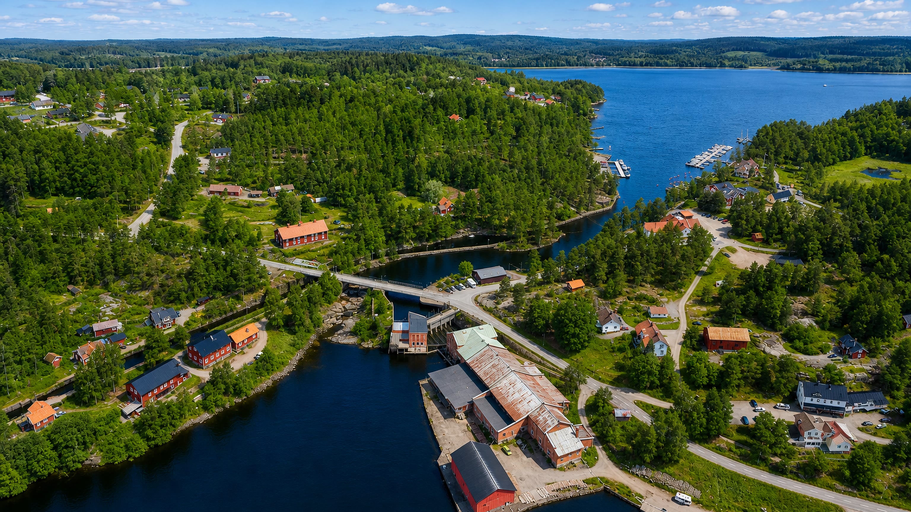 Aerial view of Årjäng by a Värmland lake with an old red mill building and marina among forest