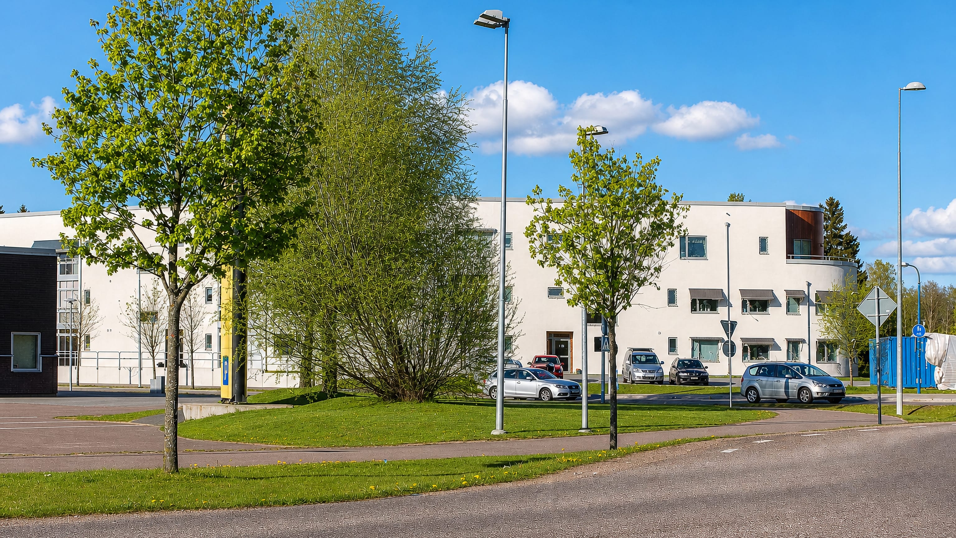 White modern school building, car park and young trees in Ratorp, Karlstad, under a clear sky.