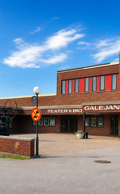 The brick facade of Storfors's Galejan theatre, cinema and library with flagpoles on the town square.