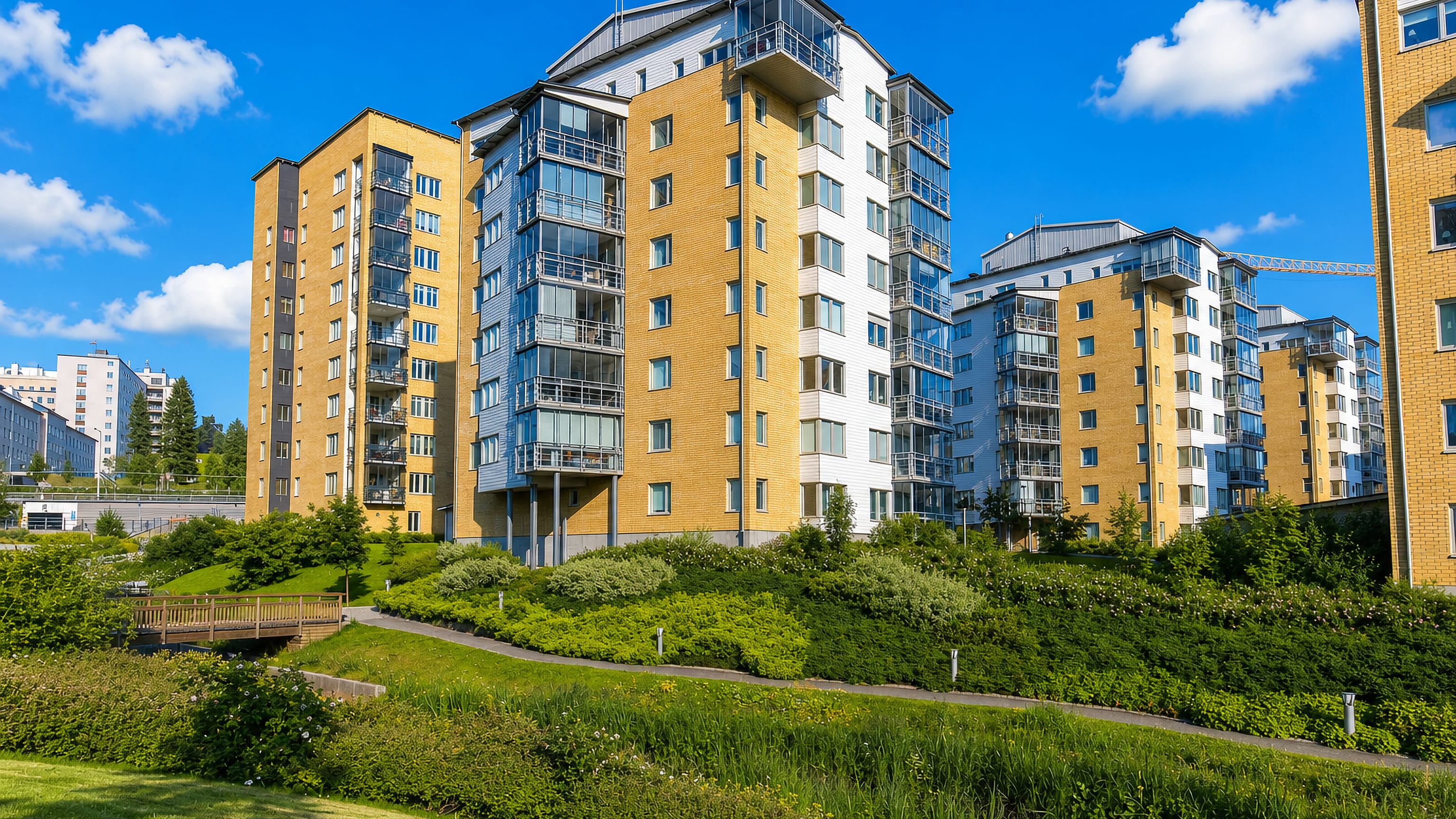 Modern yellow-brick apartment blocks with balconies above landscaped greenery in Obacka, Umea.