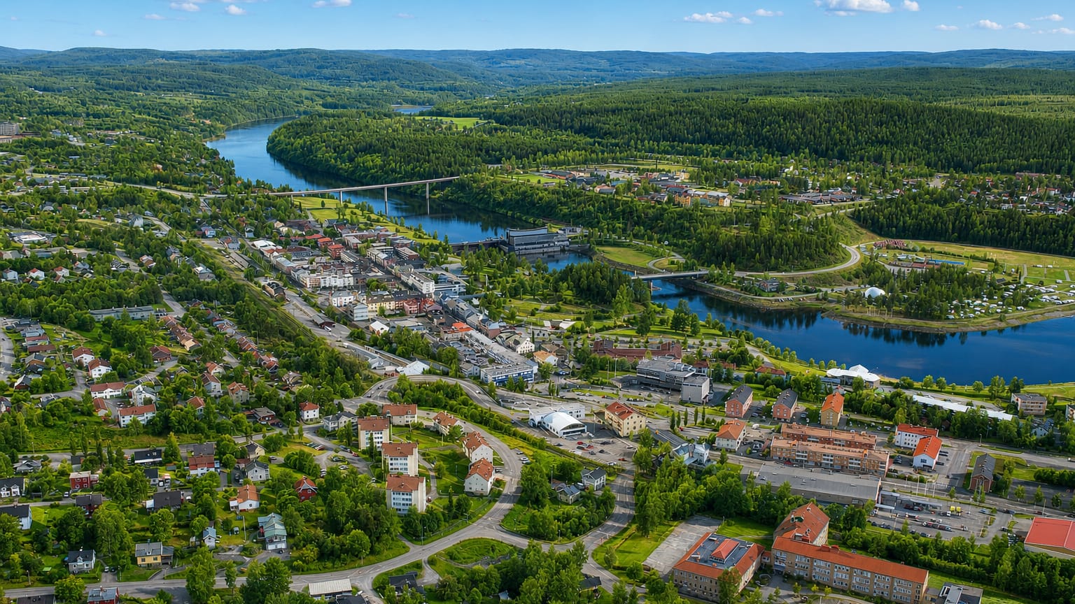 Aerial view of Sollefteaa along the Aangermanaelven river, with a bridge and forested hills in Sweden.