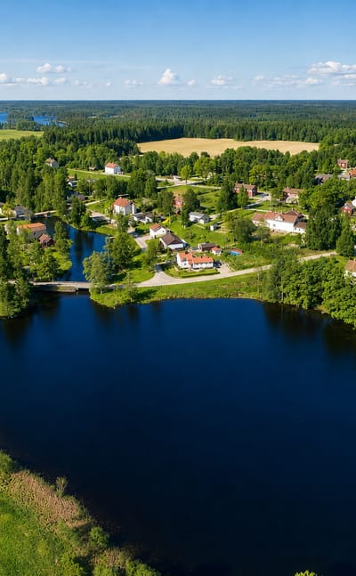 Aerial of a small village with a red church, lake and forest near Skinnskatteberg, Vastmanland, Sweden