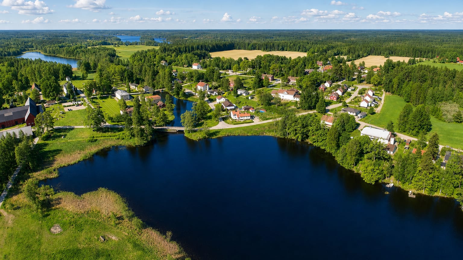 Aerial of a small village with a red church, lake and forest near Skinnskatteberg, Vastmanland, Sweden
