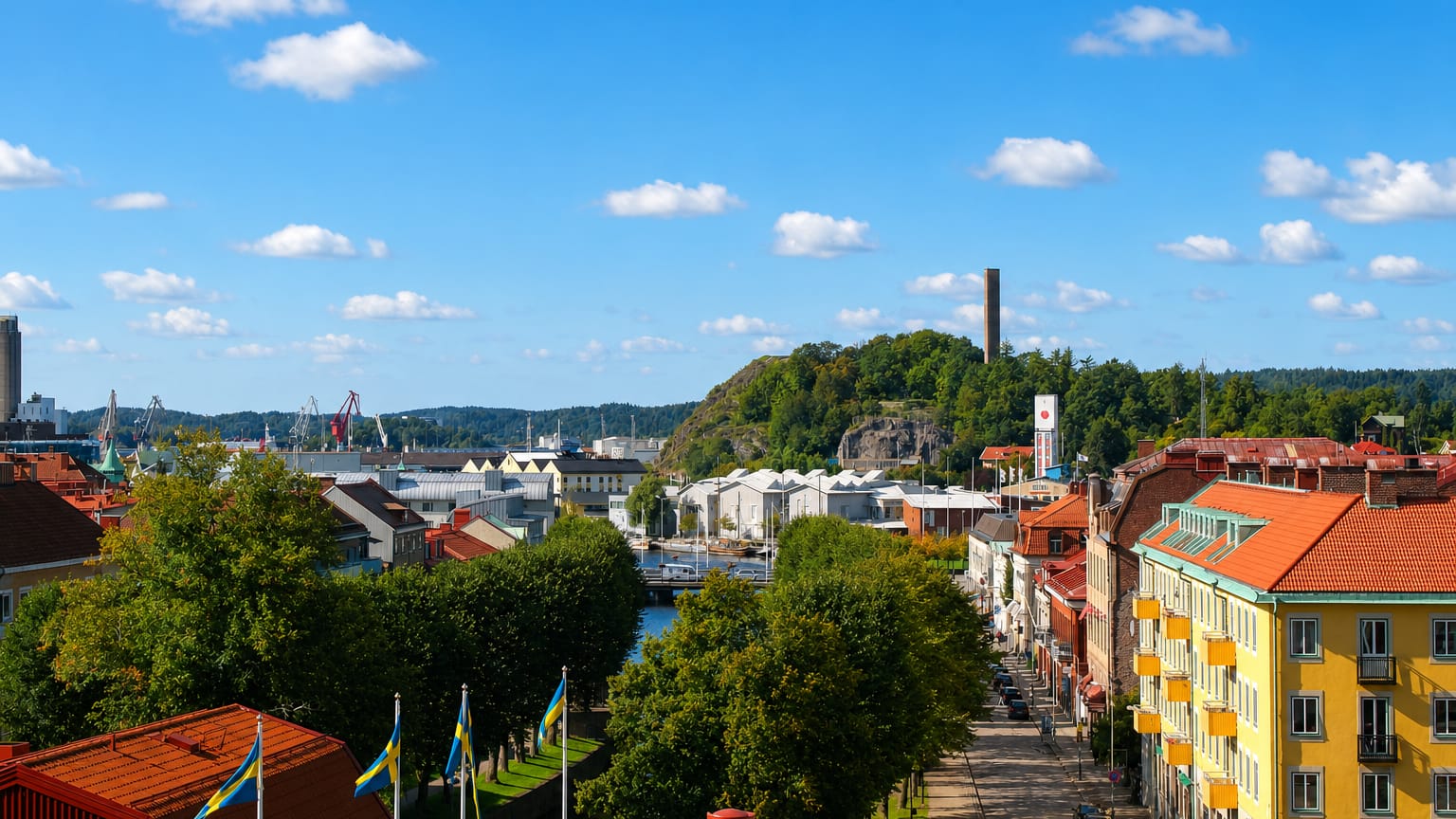 Alingsas townscape with a canal, Swedish flags, brick buildings and a wooded hill, Sweden