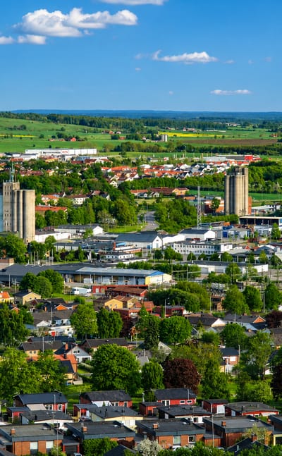 Aerial view of Falköping, Sweden with silo towers and red-roofed houses amid green farmland