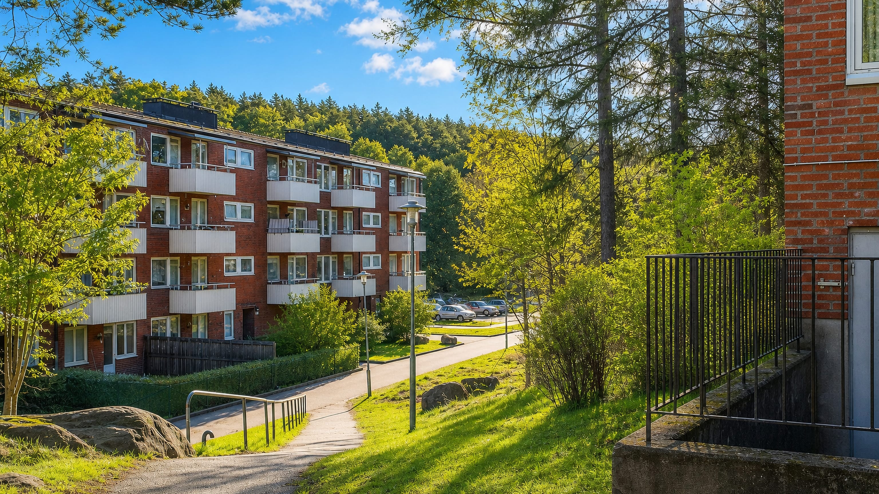 Red-brick 1950s apartment blocks with balconies among pines and granite outcrops in Kortedala, Gothenburg.