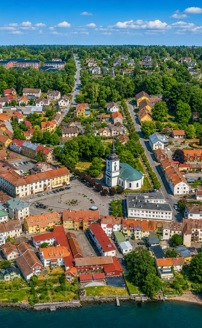 Aerial view of Hjo, Sweden, its white church, square and old wooden houses beside Lake Vättern