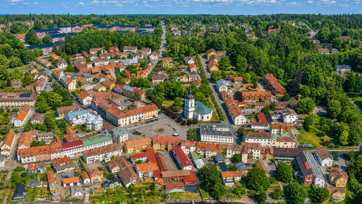 Aerial view of Hjo, Sweden, its white church, square and old wooden houses beside Lake Vättern