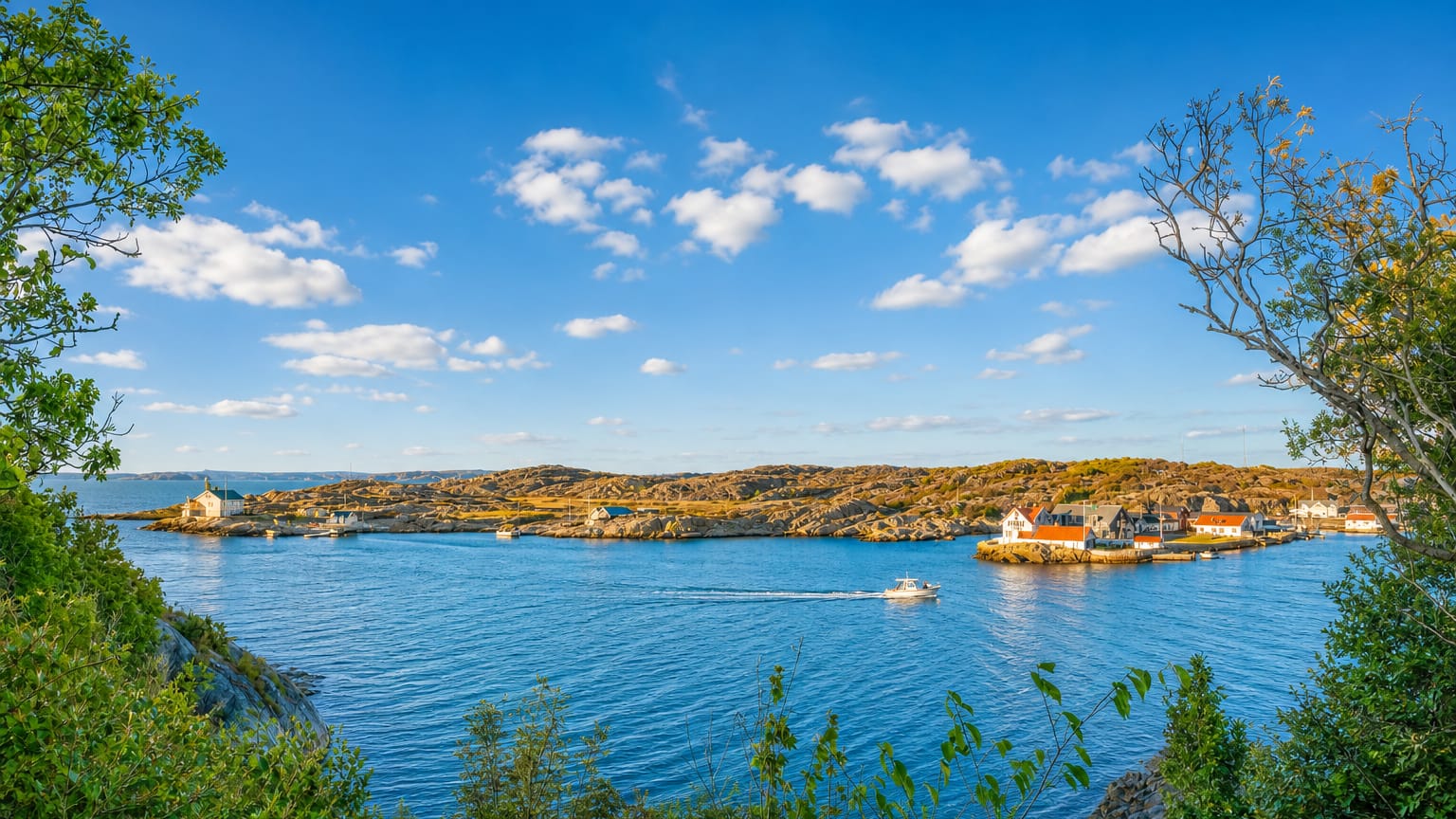 Rocky Swedish west-coast archipelago near Kungalv with blue inlets, a passing boat and scattered coastal houses