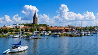 Harbour with sailboats before Mariestad, Sweden and its cathedral spire on Lake Vänern