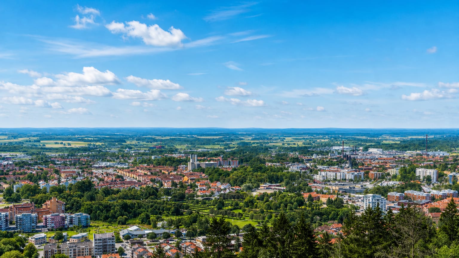 Elevated panorama over Skovde with its church tower amid green suburbs and distant plains