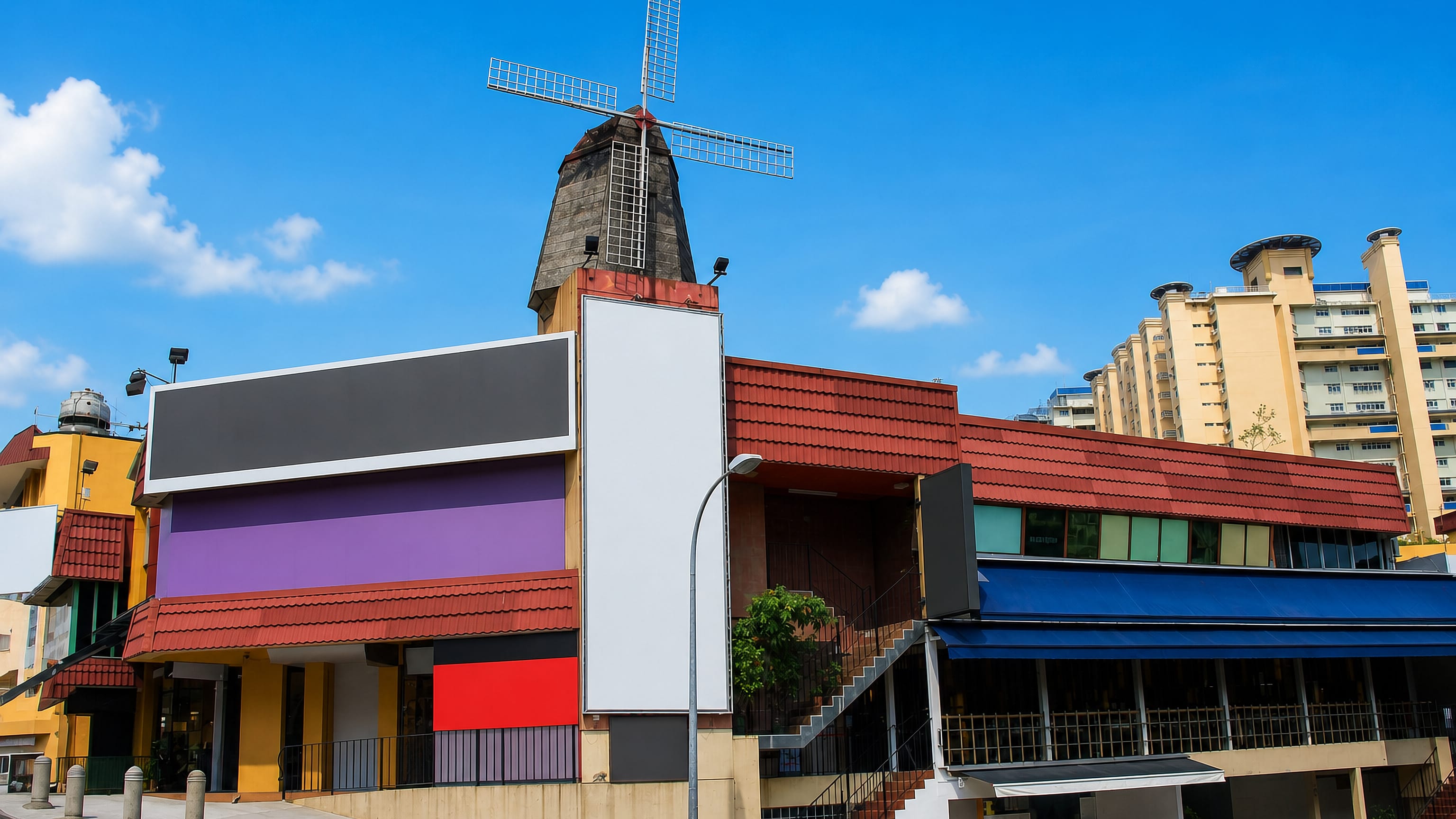 The windmill-topped landmark building at Singapore's Holland Village, with HDB blocks behind.