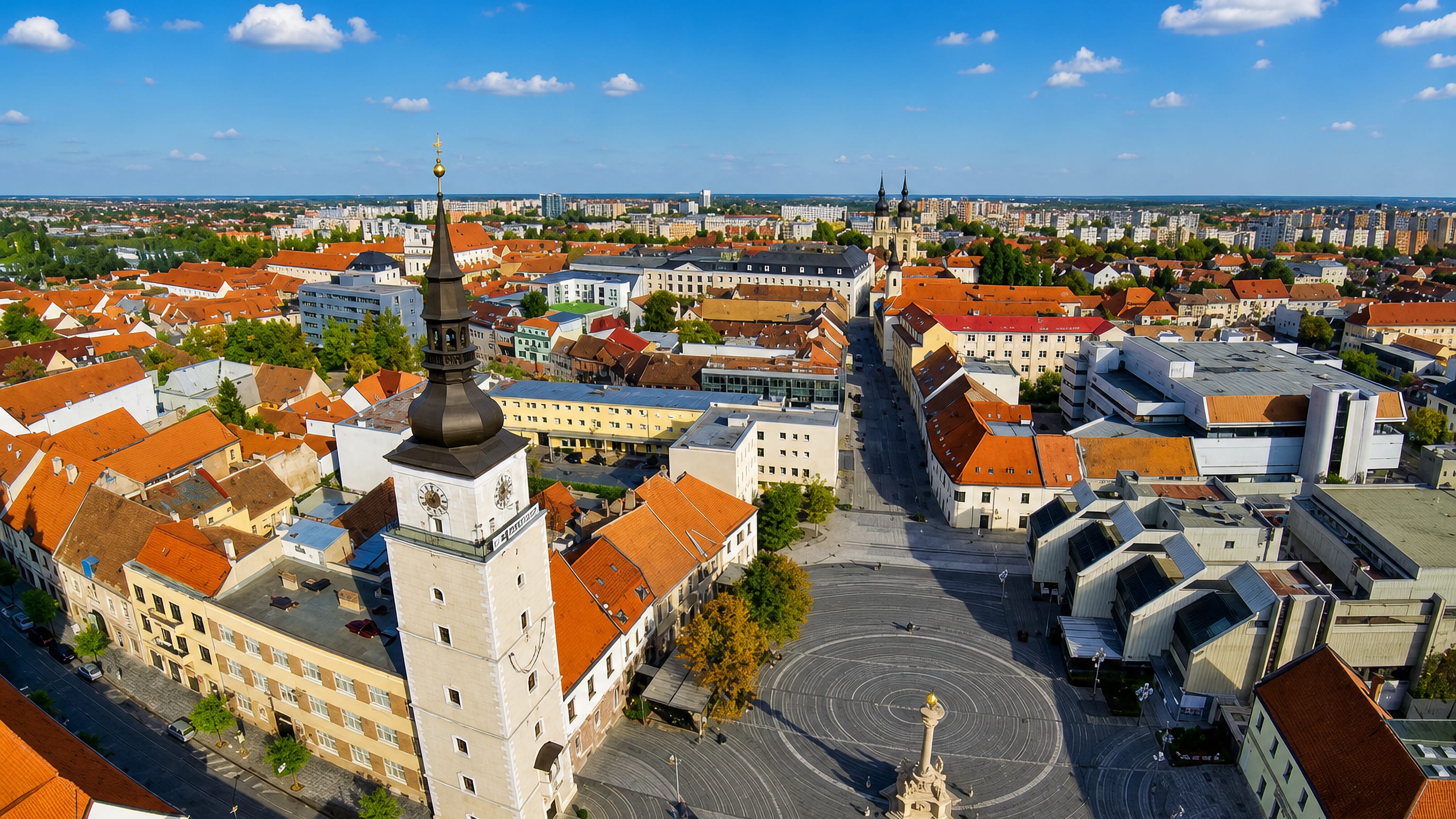 Aerial view of Trnava, Slovakia, showing the clock-topped City Tower, Trinity column and red-roofed old town.