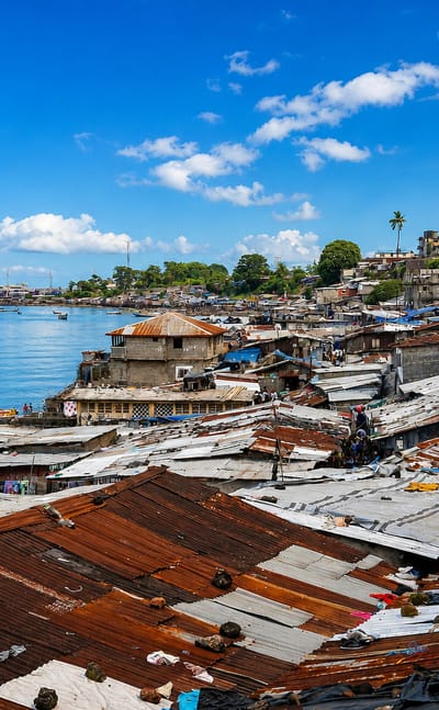 Freetown's rusted tin rooftops crowding the waterfront above the harbor and hills.