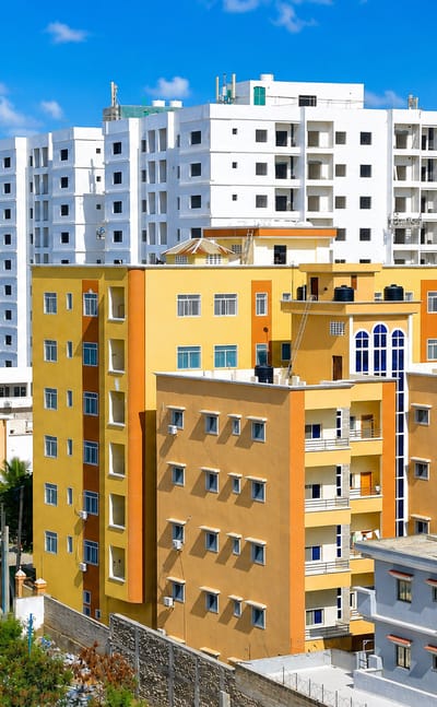 Colourful yellow and orange mid-rise apartment blocks under a bright blue sky in Mogadishu, Somalia
