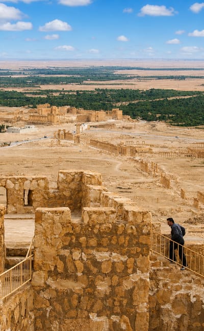 Palmyra's ancient colonnades and ruins stretching across the desert oasis below the citadel walls at Tadmur