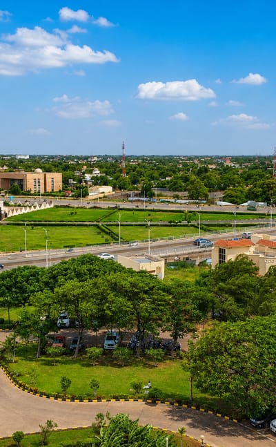 Aerial view of N'Djamena's wide green boulevards, parks and low-rise buildings under a bright Sahelian sky