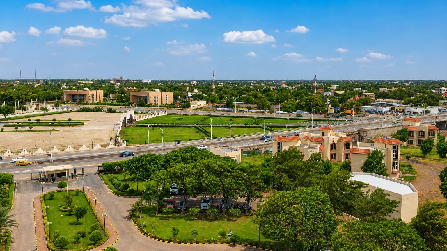 Aerial view of N'Djamena's wide green boulevards, parks and low-rise buildings under a bright Sahelian sky