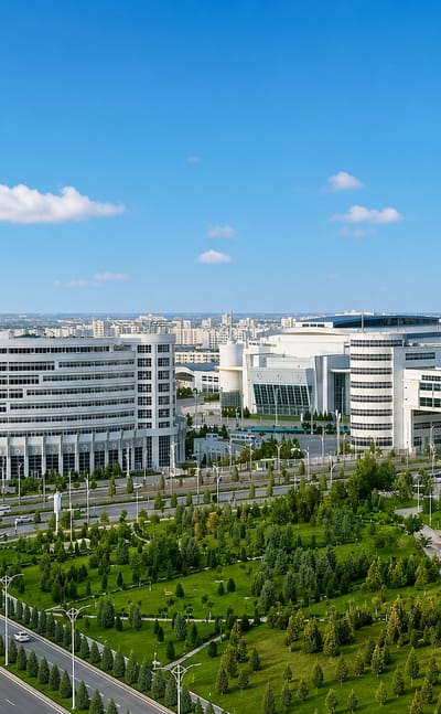 Gleaming white marble government buildings and manicured gardens along a boulevard in Ashgabat