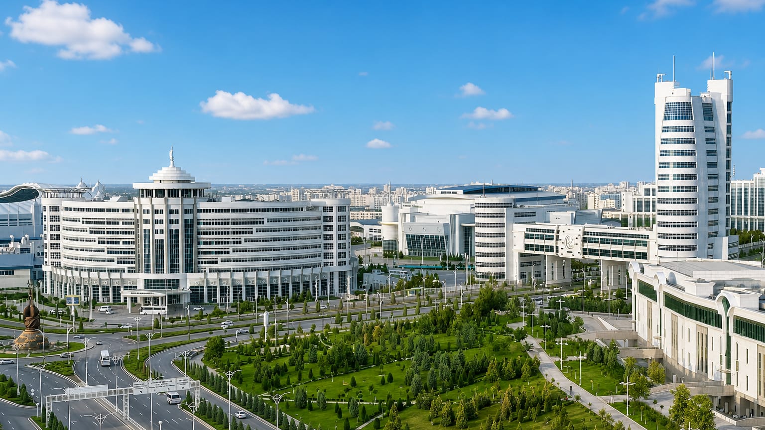 Gleaming white marble government buildings and manicured gardens along a boulevard in Ashgabat