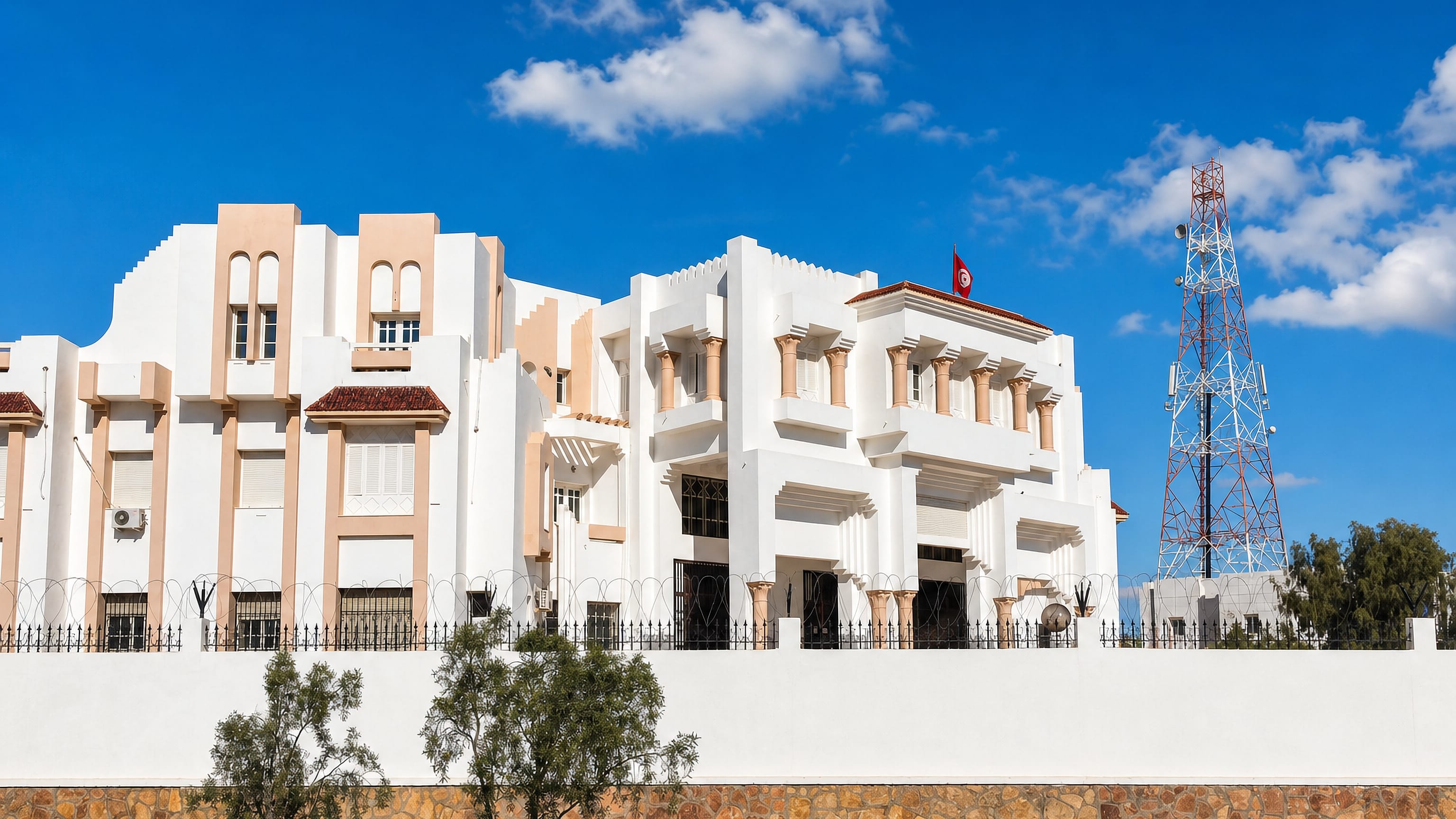 Whitewashed neo-Moorish government palace flying a Tunisian flag in Tataouine, southern Tunisia.