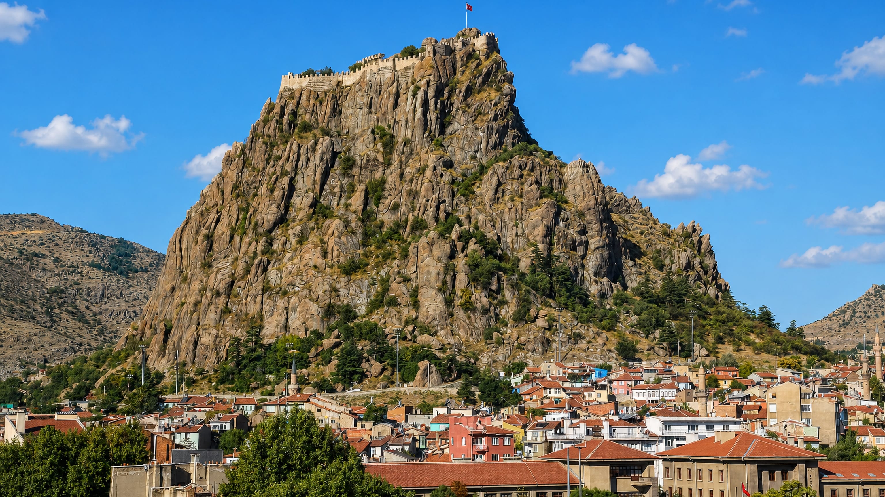 Afyonkarahisar's hilltop fortress crowning its volcanic rock above the town's red-tiled roofs.