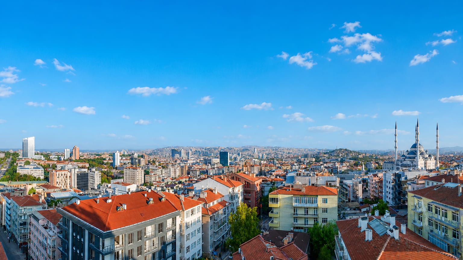 Ankara cityscape with red rooftops and the four-minaret Kocatepe Mosque against the hills