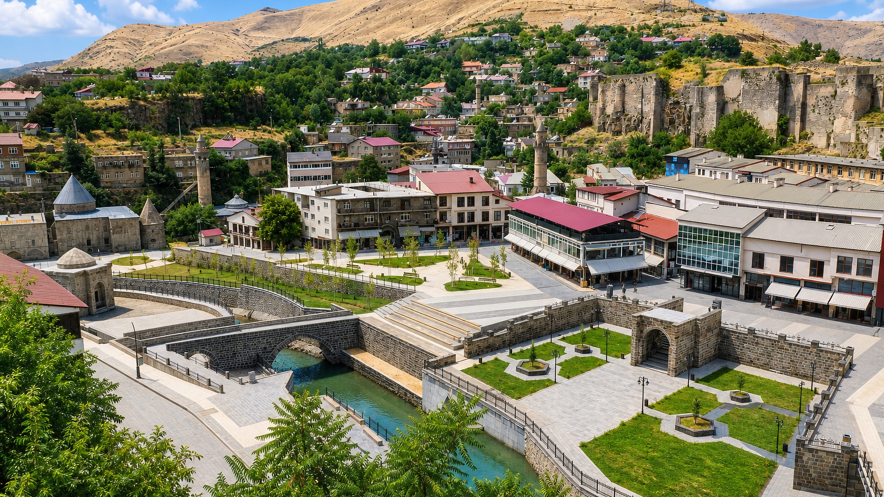 Restored square, arched stone bridge and hilltop castle walls above the stone houses of Bitlis, Turkey.