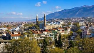 Bursa cityscape with the Grand Mosque's twin minarets below the snow-capped Uludag mountains