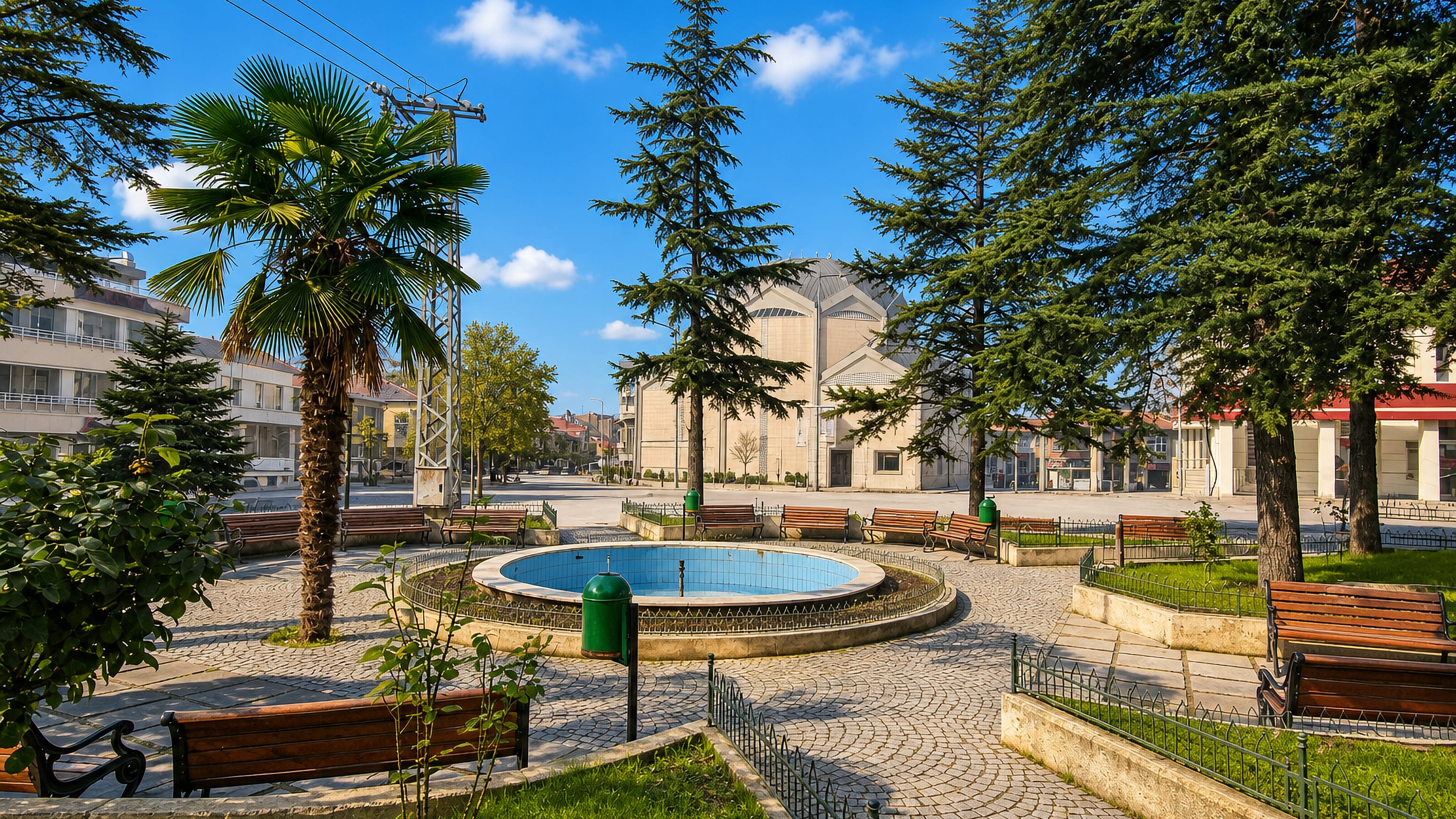 Circular fountain, cedars and benches in a town-centre park in Inegol, Bursa Province, Turkey.