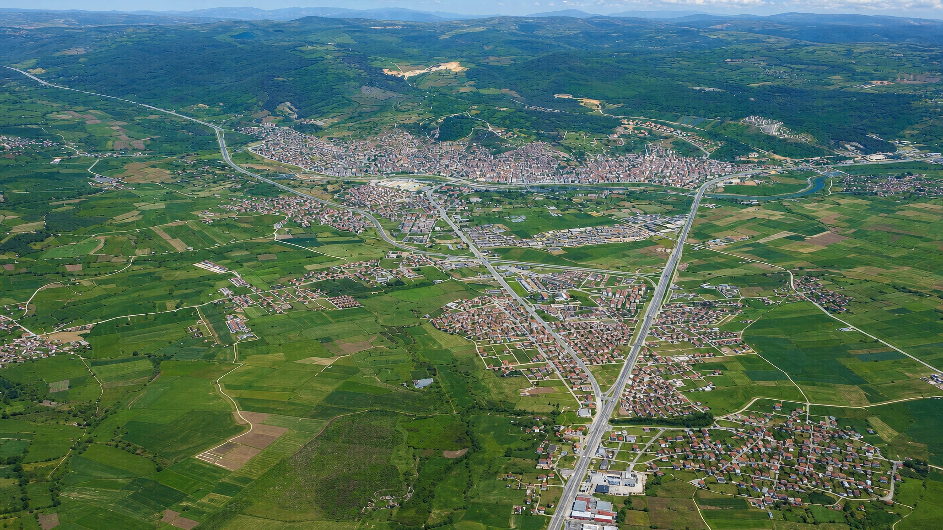 Aerial view of Biga, Turkey, spread across green farmland and low hills with a river winding past the town.
