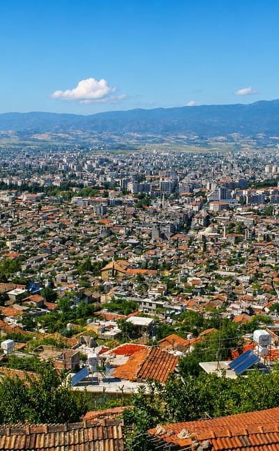 Elevated view over the red-roofed sprawl of Antakya below mountains, Hatay, Turkey