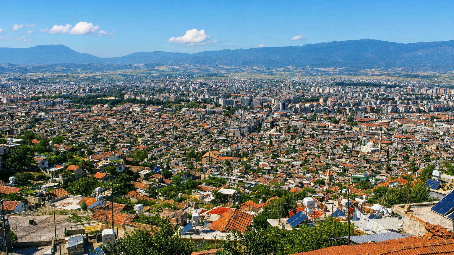 Elevated view over the red-roofed sprawl of Antakya below mountains, Hatay, Turkey