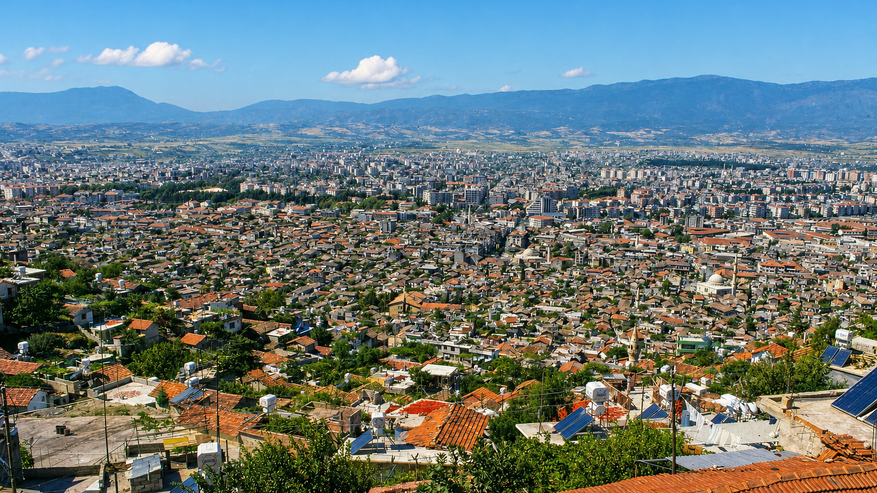 Elevated view over the red-roofed sprawl of Antakya below mountains, Hatay, Turkey