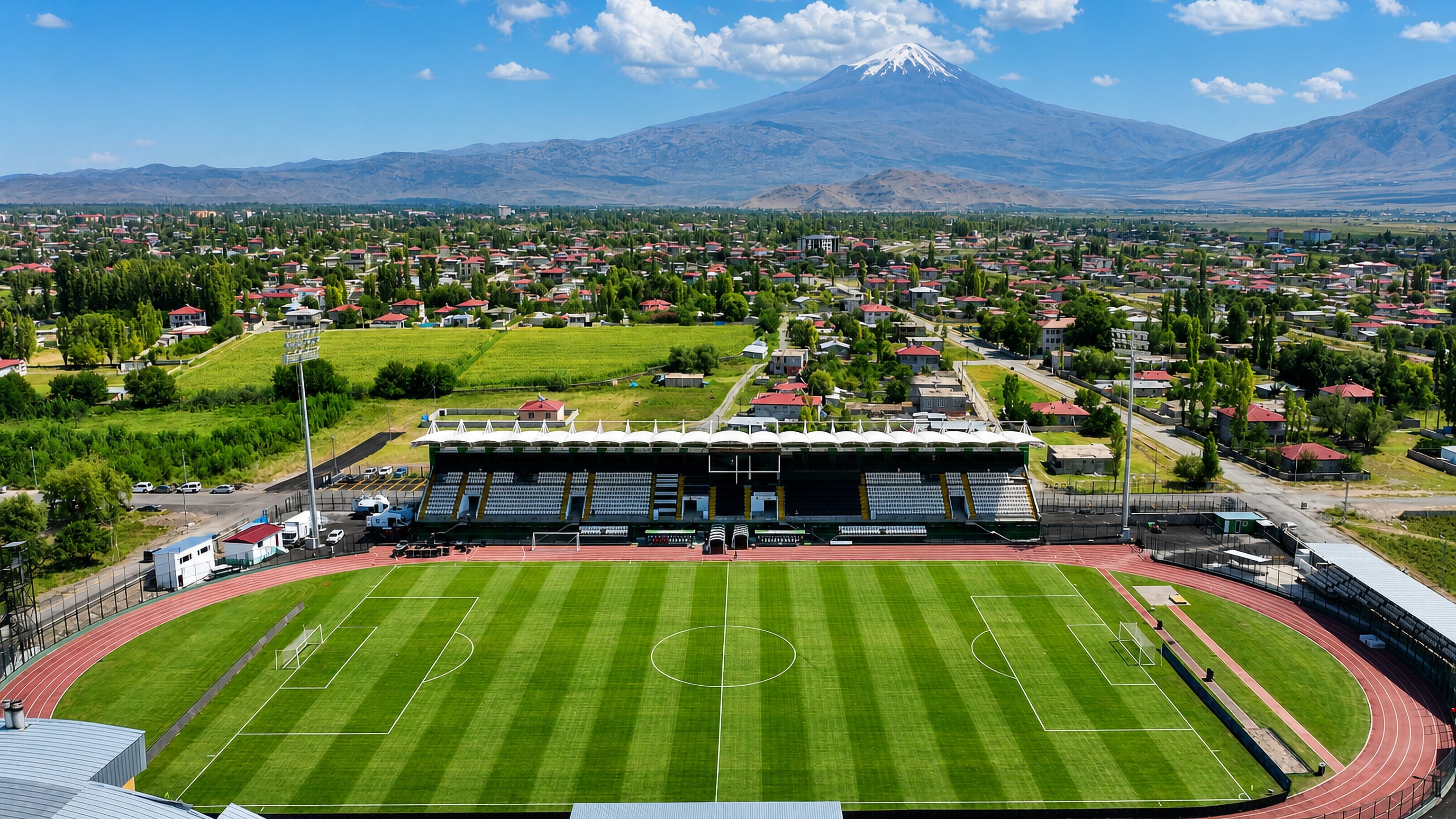 Iğdır's stadium and low-rise town spreading across the plain below the snow-capped cone of Mount Ararat