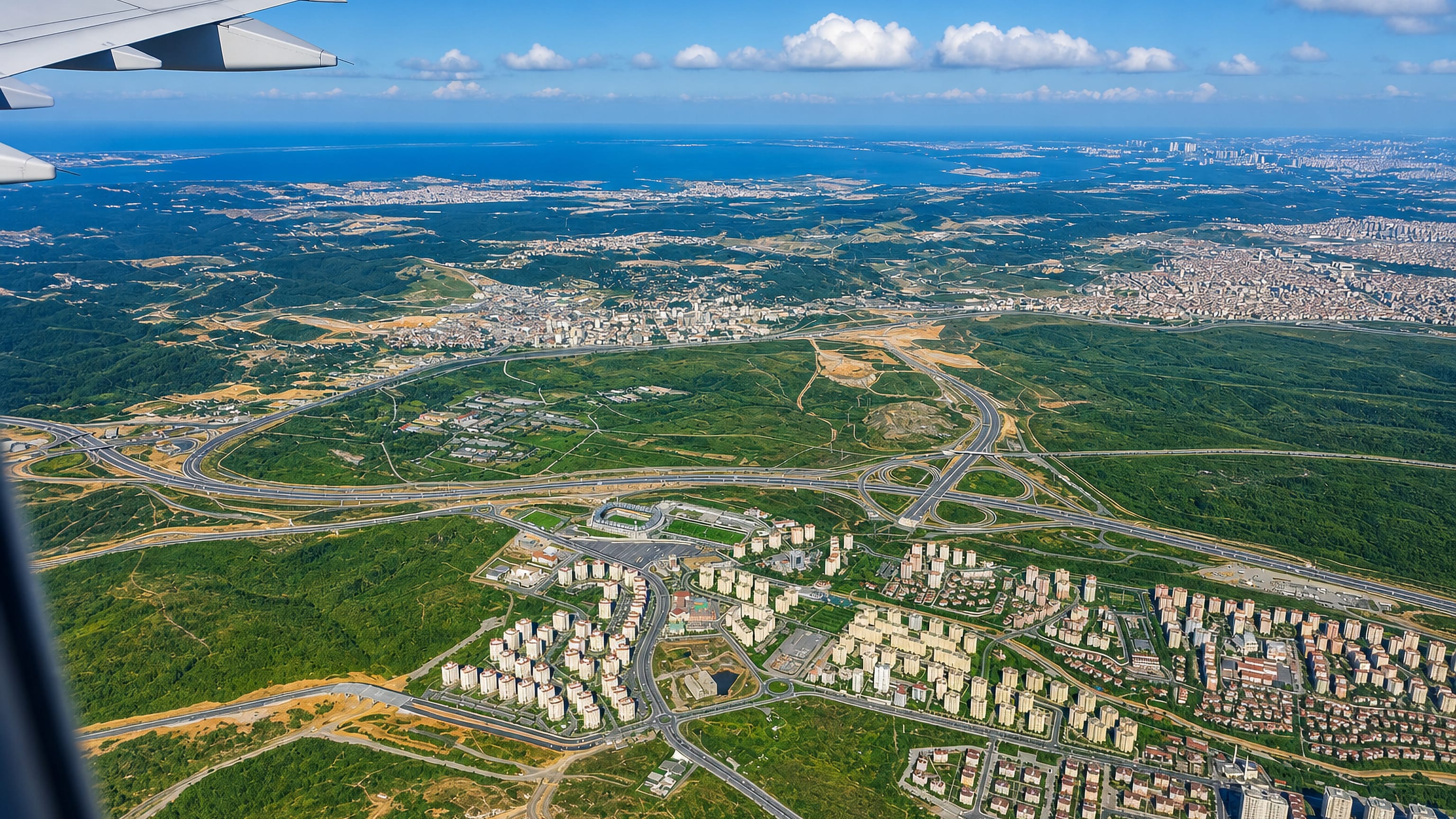Aerial view over Başakşehir, Istanbul, with rows of apartment blocks, motorway junctions and the Marmara beyond.