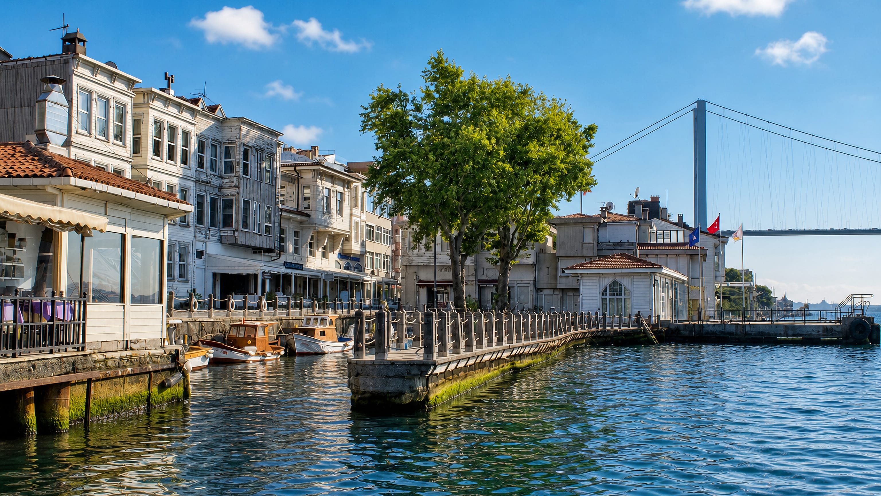Waterfront yali houses and moored boats in Beylerbeyi, Uskudar, with the Bosphorus Bridge beyond