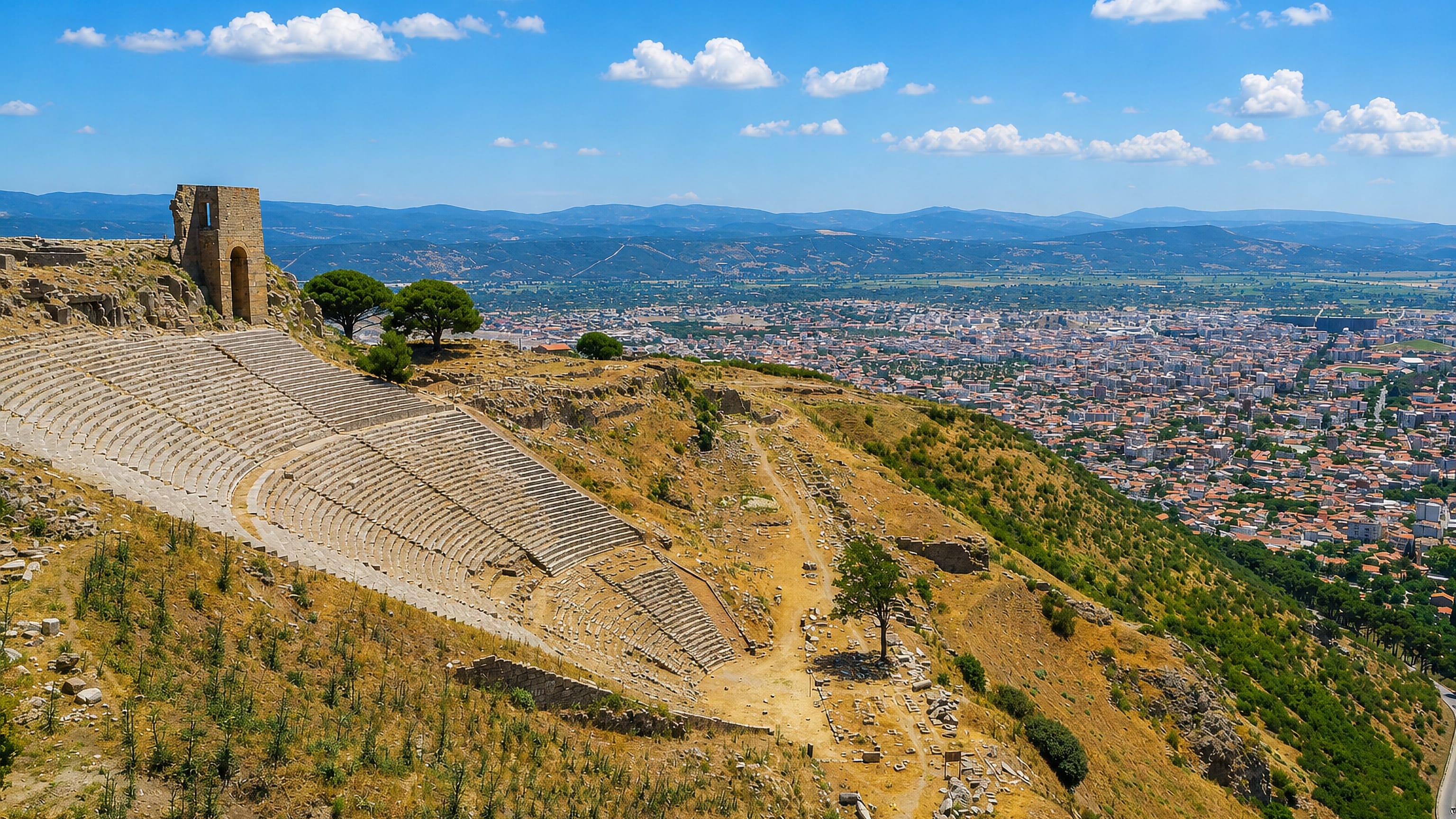 Bergama's steep Hellenistic theatre on the Pergamon acropolis, with the modern town spread across the plain below