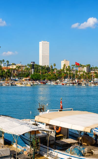 Mersin, Turkey, waterfront with fishing boats, a palm-lined promenade and the tall Metropol tower