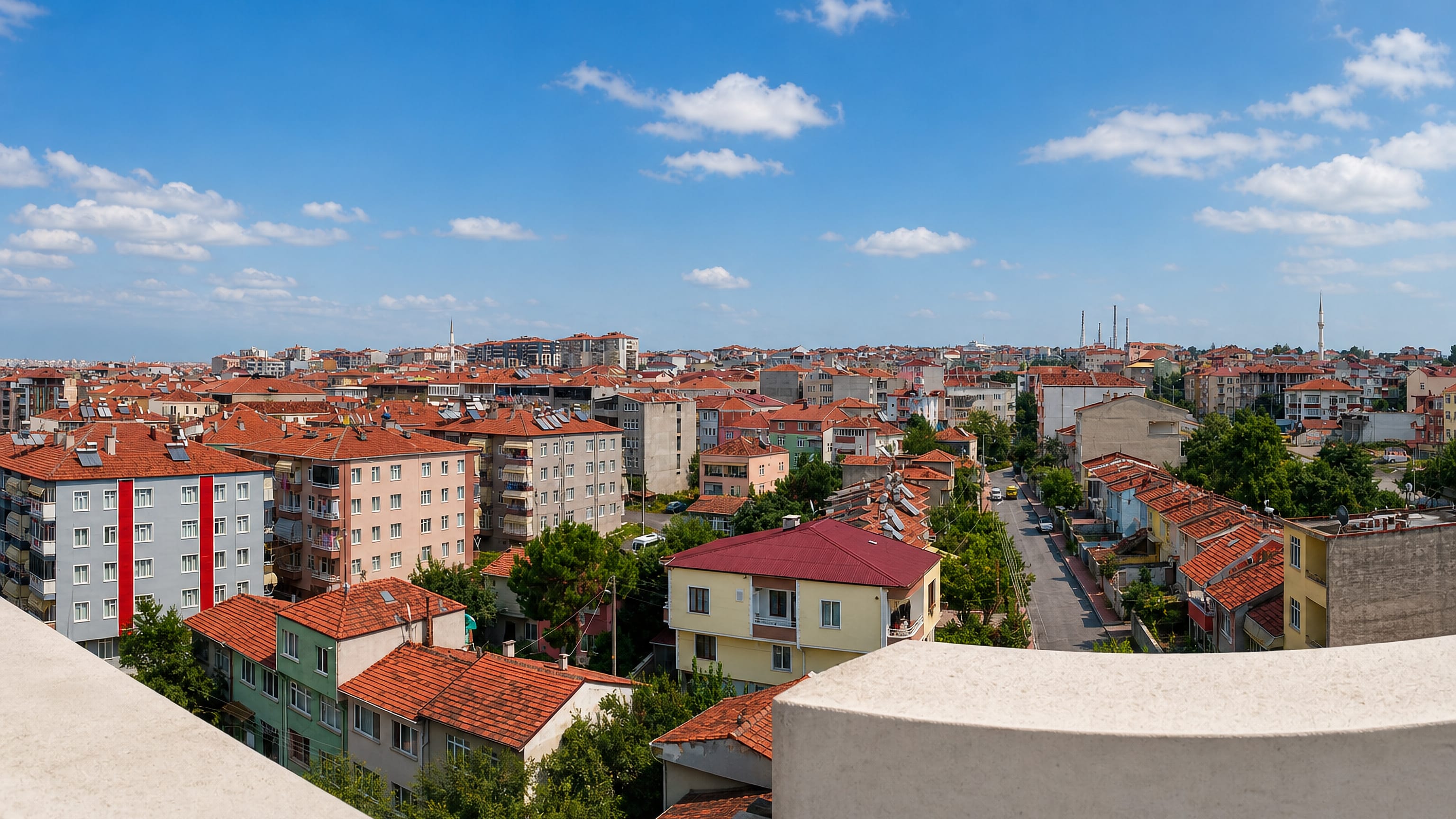 Red-tiled rooftops and minarets of Bafra, Turkey, spreading toward low hills under a bright sky.