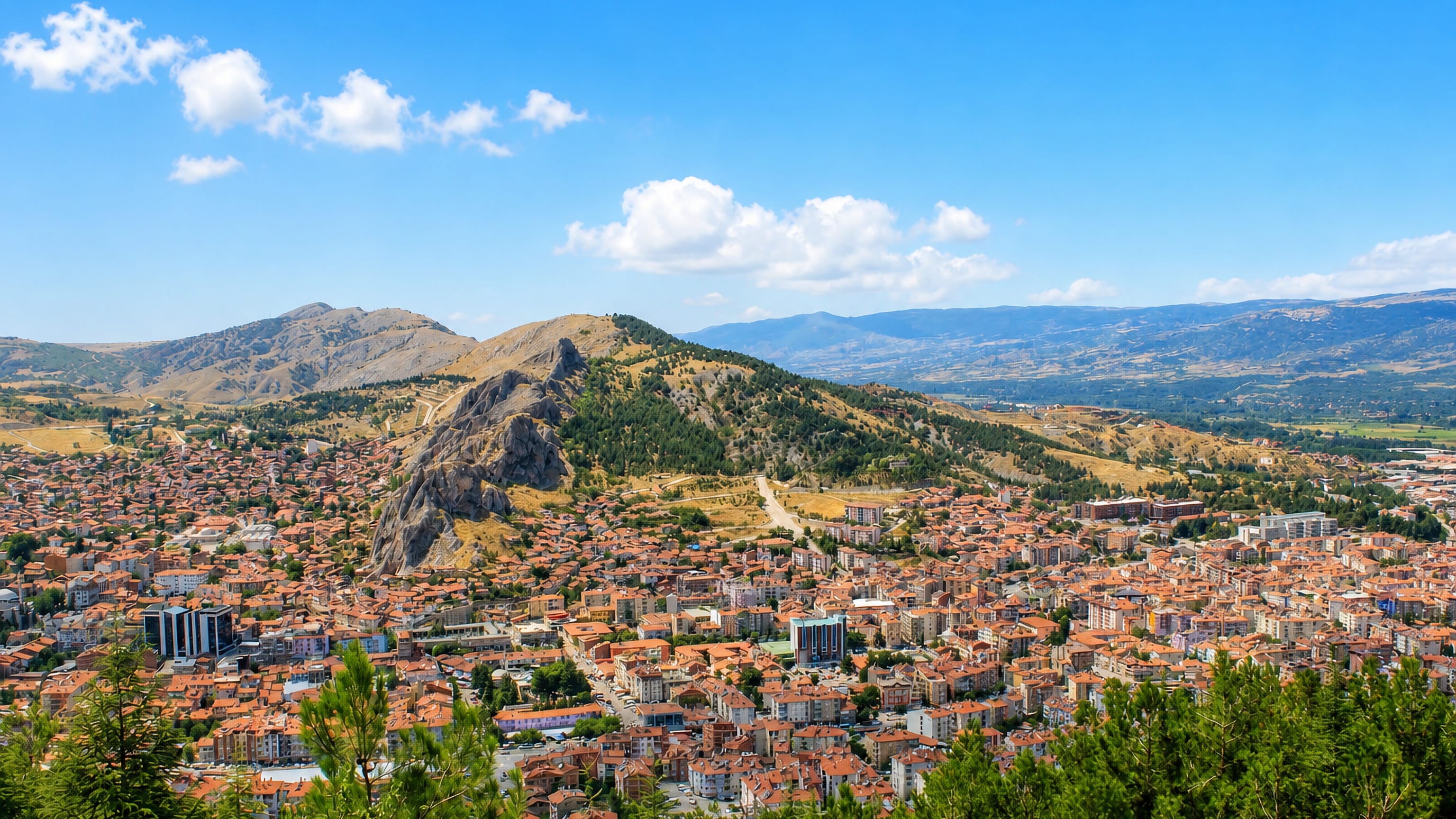 Red-roofed houses of Tokat, Turkey, spreading below the rocky crag that carries its castle.