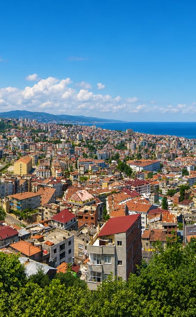 Hillside panorama of Trabzon's red-roofed houses sloping down to the Black Sea coast.