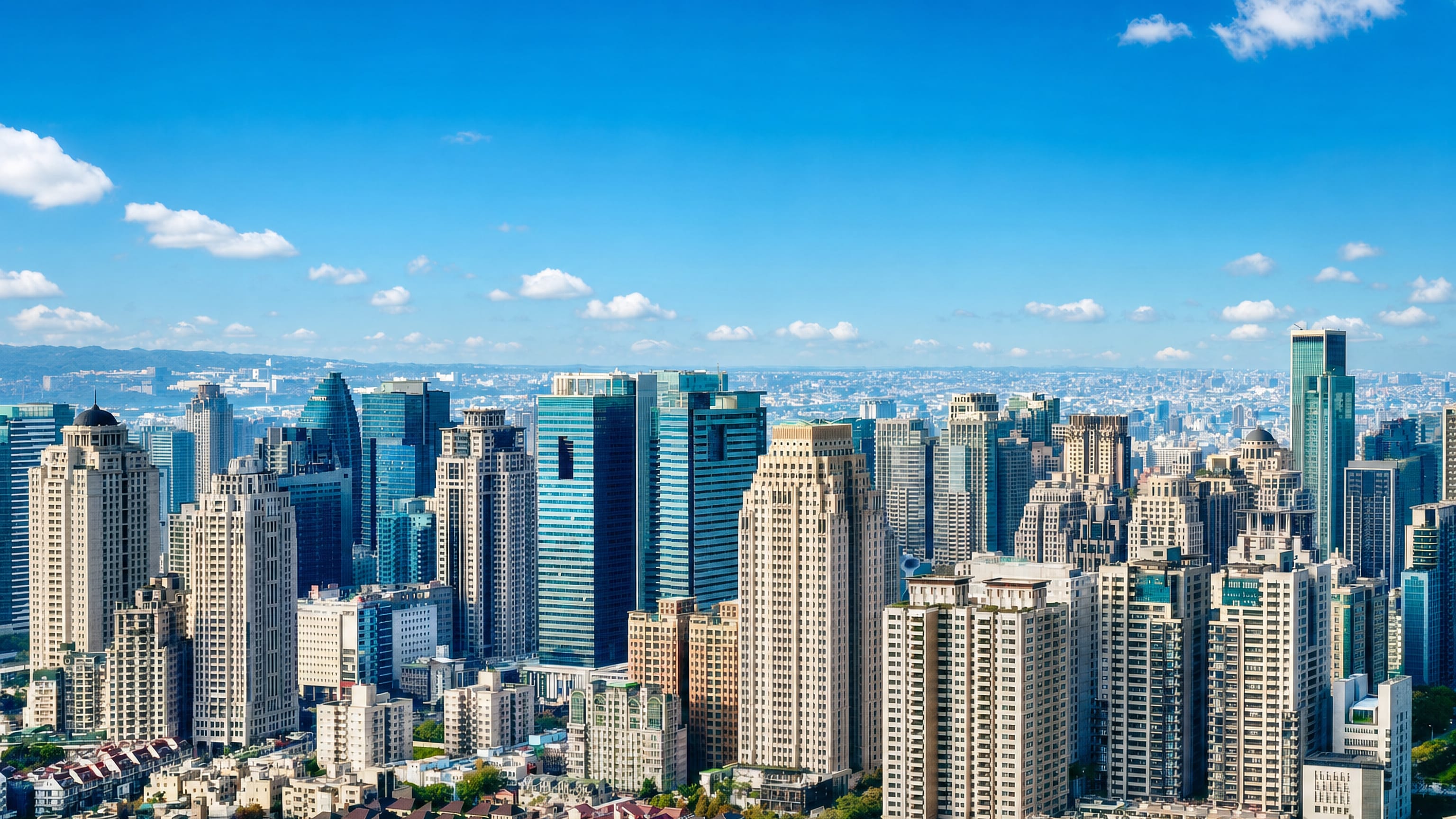 Taichung's high-rise skyline of glass office towers and apartment blocks under a clear blue sky