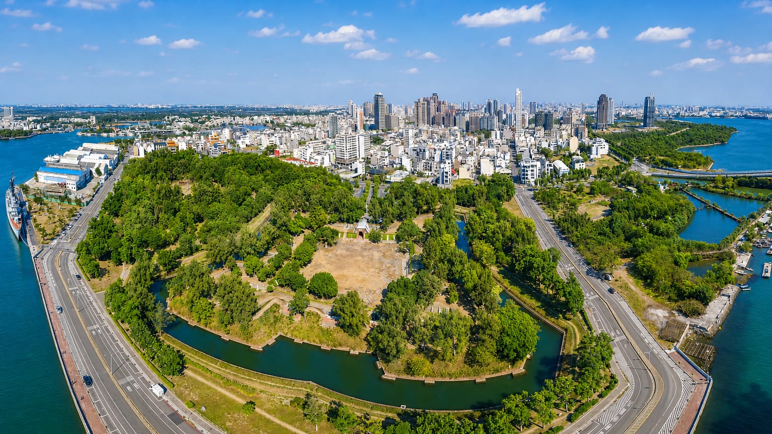 Aerial view of Tainan, Taiwan, with a fort's green earthwork ramparts and canals before the modern city skyline