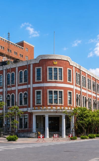 Historic red-brick colonial-era building on a sunny street corner in Taipei's Datong District.