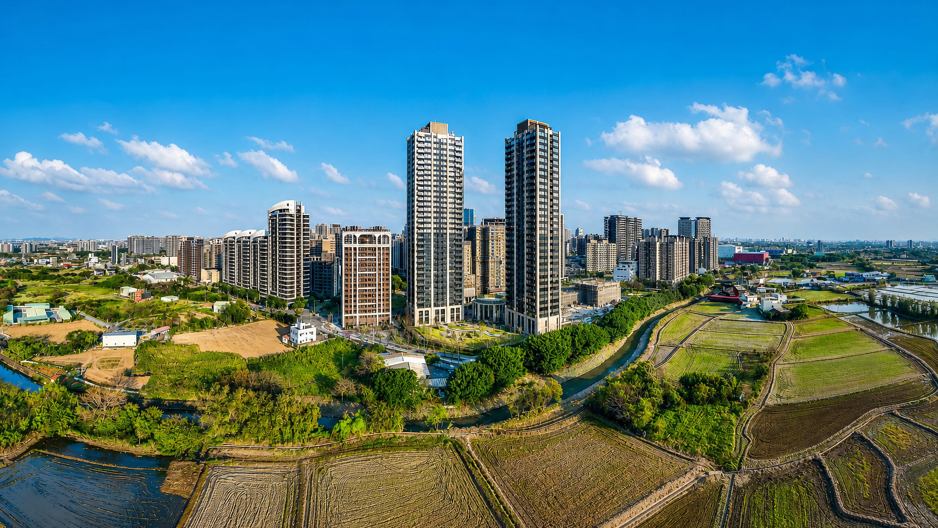 High-rise apartment towers rising above rice paddies and irrigation ponds on the edge of Taoyuan, Taiwan
