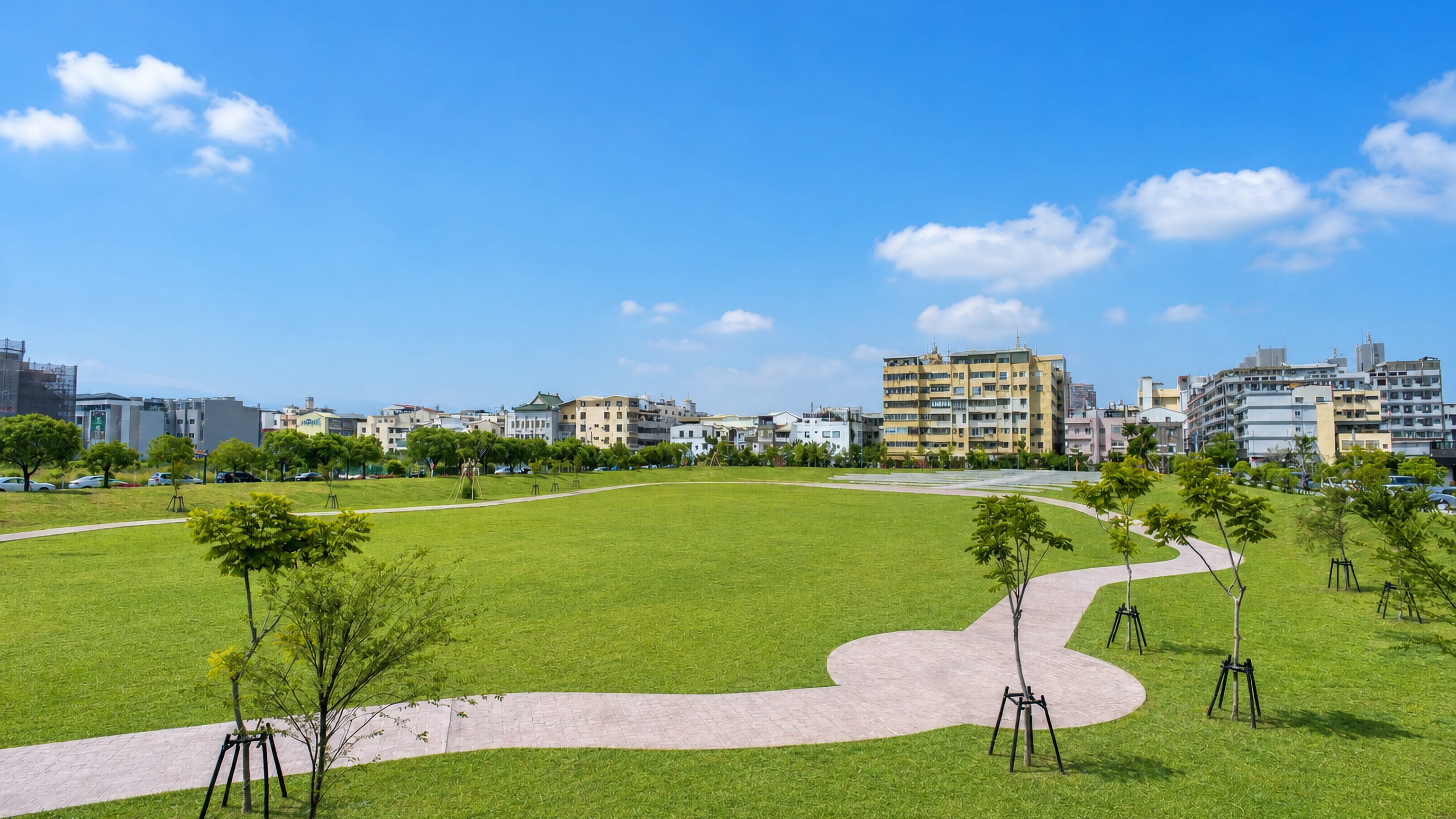 Wide lawn and winding paths of a new park backed by apartment blocks in Yuanlin, Changhua, Taiwan