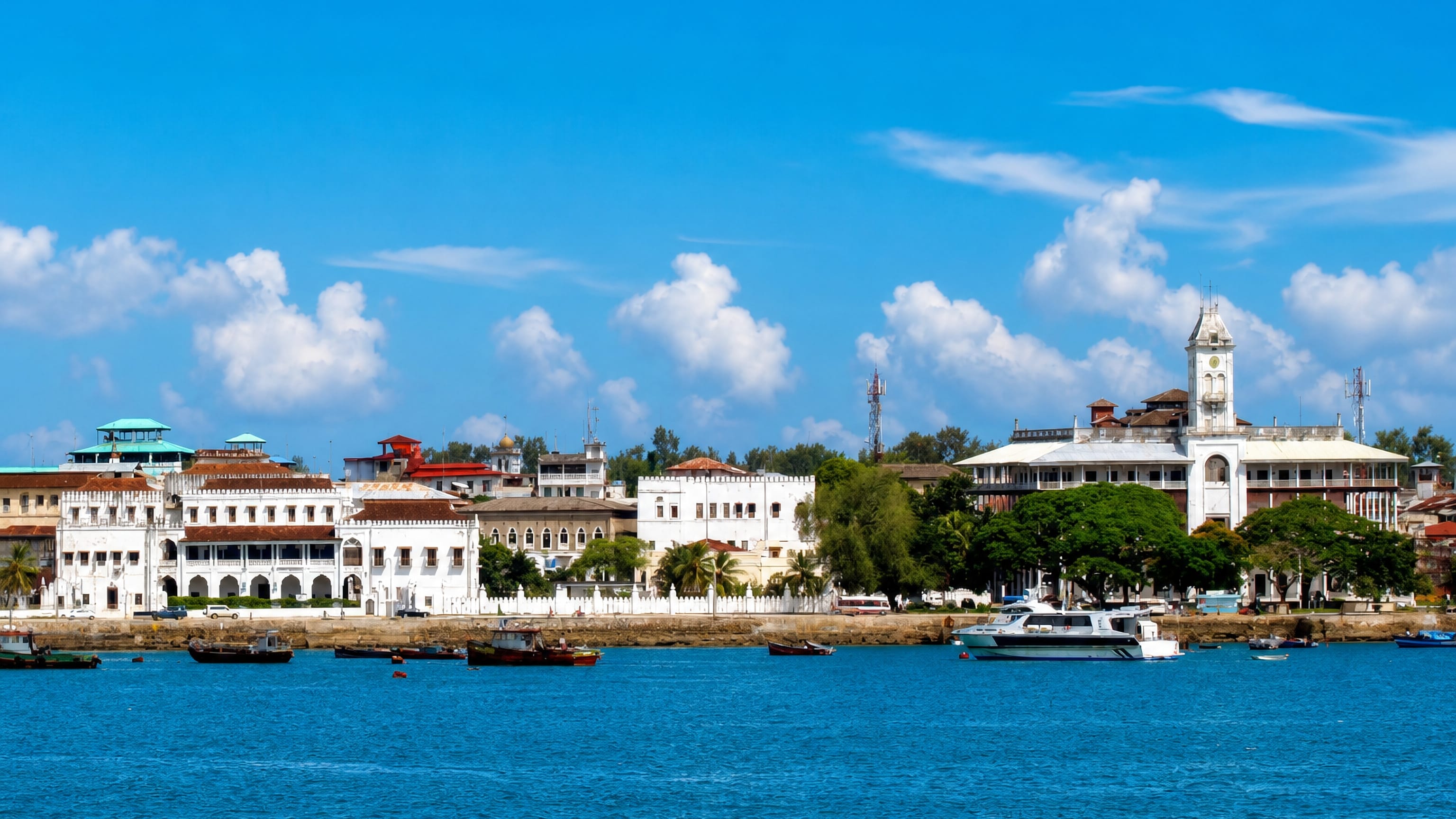 Zanzibar's Stone Town waterfront with the House of Wonders clock tower and Old Dispensary above moored boats.