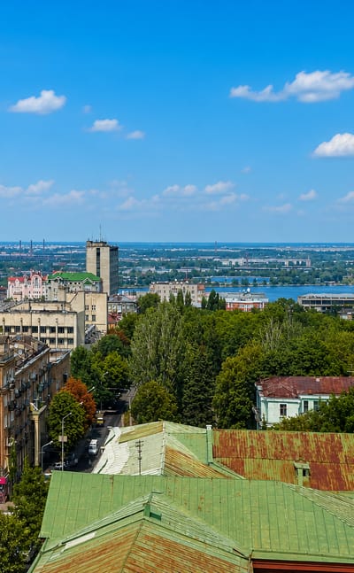 Dnipro skyline with its landmark twin towers and a gold-domed cathedral above the Dnieper River