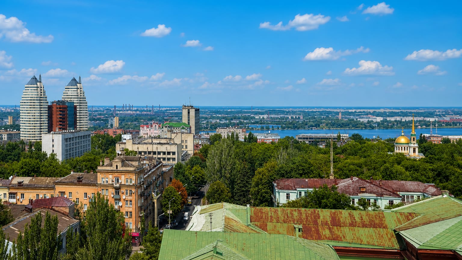 Dnipro skyline with its landmark twin towers and a gold-domed cathedral above the Dnieper River
